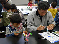 恐竜レプリカに色をぬります。