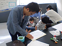 ボードの周りにテープをはるのはお父さん。