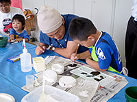 できた白いレプリカに色を塗っています。