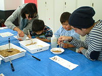 泥の中から鉱物の粒を探します。