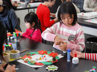 リースに恐竜などのかざりつけをします。