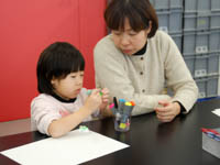 ボードのかざりの恐竜フィギュアに色をぬっています。