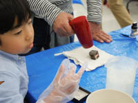 磨いた石に特殊なシールを貼り付けています。