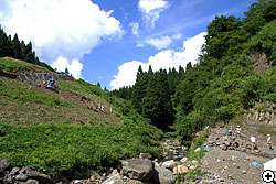 川を挟んで右手には足跡面、左手の丘の上には建設中の野外博物館が見える