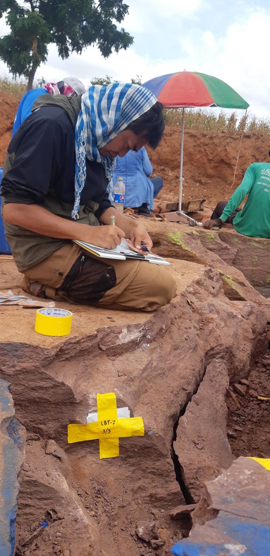 保護した化石の付いた石の上で、化石の位置を測量しているところ