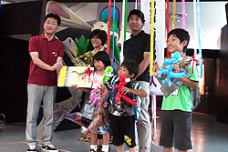 館長（左）から年間パスポートを受け取る3万人目の池田さんご家族